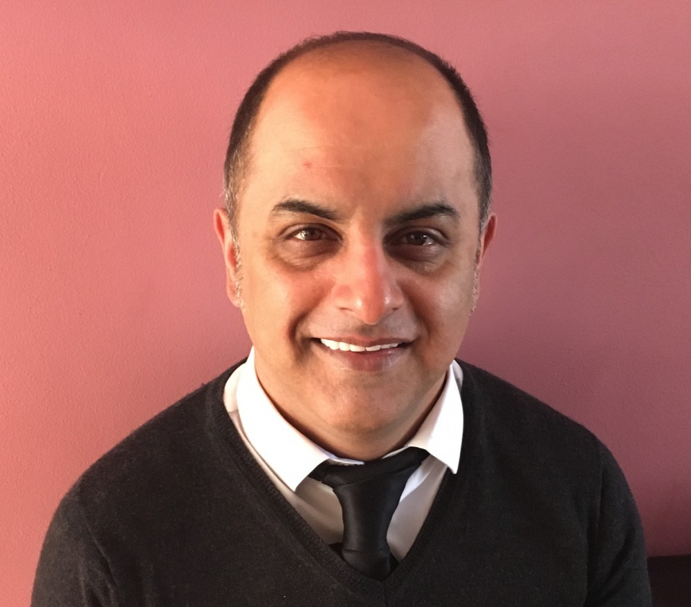 Bali Rai smiling at the camera.